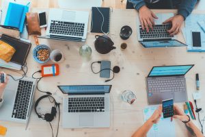 A table with laptops and people working