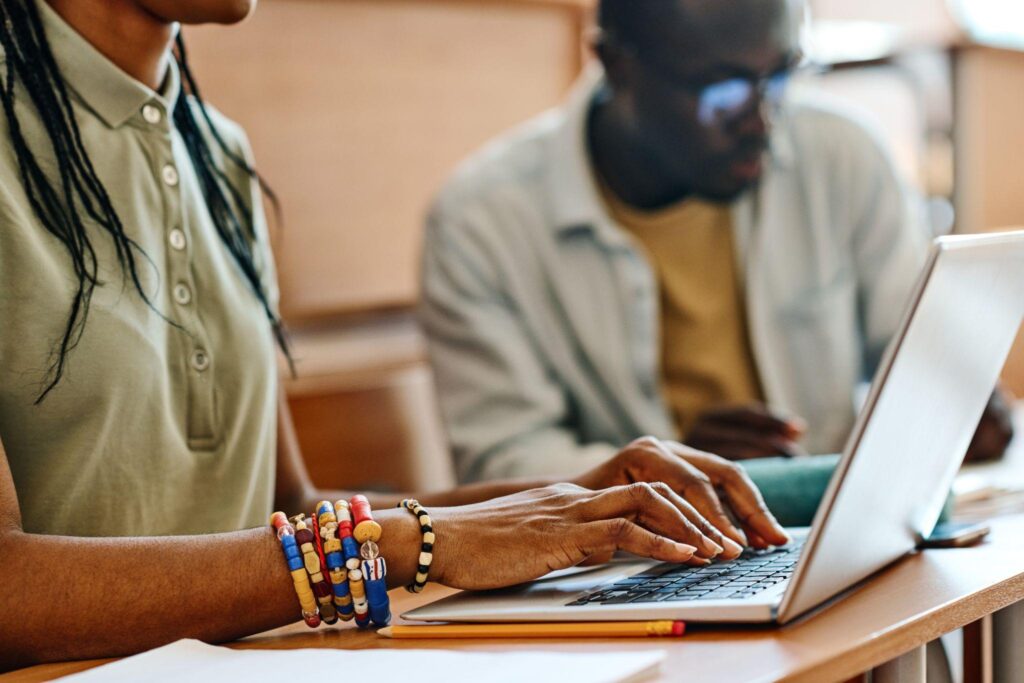 two people studying and one is typing on the laptop