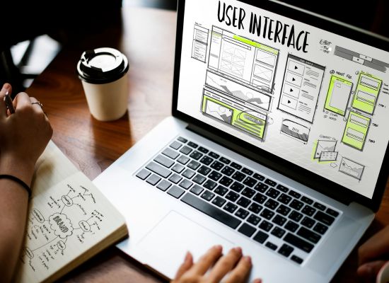 a laptop on a wooden table with user interface header and elements of user design.